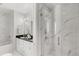 Bathroom featuring marble tile, a glass-enclosed shower, a soaking tub, and a double vanity with sleek fixtures at 150 E Robinson St # 2608, Orlando, FL 32801