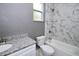 Bathroom with marble-look tile, updated vanity, and a shower-tub combination at 1508 W 16Th St, Sanford, FL 32771