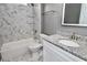 Bright bathroom featuring marble-look tiling, a modern vanity, and updated fixtures at 1508 W 16Th St, Sanford, FL 32771