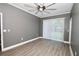 Cozy bedroom showcasing grey walls, wood-look floors, ceiling fan, and natural light at 1508 W 16Th St, Sanford, FL 32771