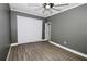 Bedroom featuring grey walls, wood-look flooring, a ceiling fan and blinds on the windows at 1508 W 16Th St, Sanford, FL 32771