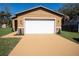Home's exterior with a two-car garage, stone accents, fresh paint, new driveway and manicured landscaping at 1508 W 16Th St, Sanford, FL 32771