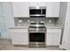Modern kitchen with stainless steel appliances, granite counters, white cabinets, and gray walls at 1508 W 16Th St, Sanford, FL 32771
