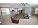 Bright open concept with a leather sofa, wood floors, fan, and white kitchen at 1508 W 16Th St, Sanford, FL 32771