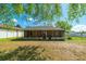 Lovely screened porch in the backyard overlooking lush green lawn and white fence at 15733 Switch Cane St, Clermont, FL 34711