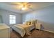 Comfortable bedroom with a ceiling fan, a cozy bed with plush pillows and carpeted floors at 15733 Switch Cane St, Clermont, FL 34711
