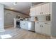 Bright kitchen featuring white cabinets, stainless steel appliances, and light grey backsplash tiles at 15733 Switch Cane St, Clermont, FL 34711