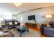 Cozy living room features hardwood floors, a ceiling fan, and ample seating with couches and a TV at 15733 Switch Cane St, Clermont, FL 34711