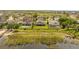 An aerial view showcases backyards, covered patios, and waterfront properties along a lush shoreline at 16689 Broadwater Ave, Winter Garden, FL 34787