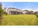 Expansive backyard featuring a covered patio, lush lawn, and secure fencing at 16689 Broadwater Ave, Winter Garden, FL 34787