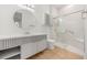 Well-lit bathroom with a modern vanity, round mirror, and a glass-enclosed shower at 16689 Broadwater Ave, Winter Garden, FL 34787
