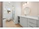 Bright bathroom featuring a modern vanity with white countertop and decorative mirror, and tiled walk-in shower at 16689 Broadwater Ave, Winter Garden, FL 34787