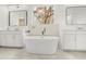 Luxurious bathroom featuring a modern freestanding tub, dual vanities and natural light at 16689 Broadwater Ave, Winter Garden, FL 34787