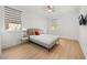 Bedroom with wood floor, gray bed with adjacent lamps on nightstands, and striped window shades at 16689 Broadwater Ave, Winter Garden, FL 34787