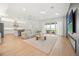 Open-concept living area featuring a sleek kitchen, a comfortable sofa, a modern fireplace, and scenic outdoor views at 16689 Broadwater Ave, Winter Garden, FL 34787
