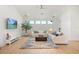 Well-lit living room with modern sofas, a tree, and a large window offering natural light at 16689 Broadwater Ave, Winter Garden, FL 34787