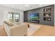 Cozy living room featuring a fireplace, large windows, a modern television, and stylish furnishings at 16689 Broadwater Ave, Winter Garden, FL 34787