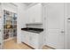 Well-organized pantry with white cabinets, black countertops, and open shelving at 16689 Broadwater Ave, Winter Garden, FL 34787