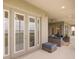 Covered outdoor patio with comfortable wicker furniture, ceiling fan, and a view of the lake at 16689 Broadwater Ave, Winter Garden, FL 34787