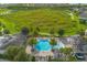 Aerial view of a stunning community pool with palm trees and lounge chairs overlooking a lush green space and walking path at 16689 Broadwater Ave, Winter Garden, FL 34787