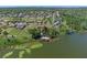 Aerial view of home on the lake with boat dock and wooded property at 16752 Caravaggio Loop, Montverde, FL 34756