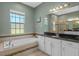 Beautiful bathroom with a soaking tub, decorative tile work, a window, and double sinks at 16752 Caravaggio Loop, Montverde, FL 34756
