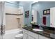 This bathroom features a shower-tub combo, granite countertops, and tiled walls at 16752 Caravaggio Loop, Montverde, FL 34756