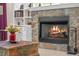Close-up of the stone fireplace with a warm fire burning, creating a cozy ambiance at 16752 Caravaggio Loop, Montverde, FL 34756