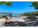 Sandy beachfront featuring a dock with chairs for lakeside relaxation at 16752 Caravaggio Loop, Montverde, FL 34756