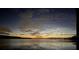 Serene water view at dusk reflecting sky with orange glow on water at 16752 Caravaggio Loop, Montverde, FL 34756