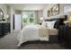 Serene bedroom showcasing neutral tones, soft carpet, and a decorative mirror above the headboard at 17411 Million Lakes Ct, Clermont, FL 34714