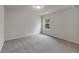 Bedroom with neutral carpet flooring, a single window providing natural light, and fresh, neutral paint at 17411 Million Lakes Ct, Clermont, FL 34714
