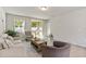 Bright and airy living room with modern decor, tile flooring, and sliding glass doors leading to the backyard at 17411 Million Lakes Ct, Clermont, FL 34714