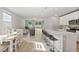 Open-concept kitchen featuring white cabinets, stainless steel appliances, and island with bar seating at 17411 Million Lakes Ct, Clermont, FL 34714