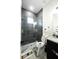 Modern bathroom with a gray tiled shower, glass door and granite vanity at 18721 Seaview St, Orlando, FL 32833
