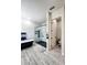 Contemporary bathroom showcasing a glass-enclosed shower with black tile, a black soaking tub, and gray wood-look flooring at 18721 Seaview St, Orlando, FL 32833
