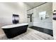 Modern bathroom featuring a soaking tub, a glass shower with wall-mounted fixtures, and light tile floors at 18721 Seaview St, Orlando, FL 32833