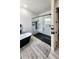 Contemporary bathroom showcasing a glass-enclosed shower with black tile, a black soaking tub, and gray wood-look flooring at 18721 Seaview St, Orlando, FL 32833