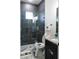 Contemporary bathroom with a gray tiled shower, clear glass door and granite topped dark vanity at 18721 Seaview St, Orlando, FL 32833