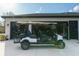 Three car garage with an open door revealing plenty of storage and a golf cart in the driveway at 18721 Seaview St, Orlando, FL 32833
