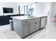Kitchen island featuring gray cabinets, modern sink, and seating space in an open kitchen at 18721 Seaview St, Orlando, FL 32833
