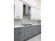Modern kitchen showcasing two-toned cabinets, stainless steel range hood, and stylish backsplash, offering an elegant cooking space at 18721 Seaview St, Orlando, FL 32833