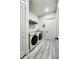Modern laundry room with a front load washer/dryer, sink, folding table and bright white walls at 18721 Seaview St, Orlando, FL 32833