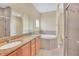 Bright bathroom featuring double sinks, granite countertops, a soaking tub, and separate shower at 2311 Whitley Ln, Winter Haven, FL 33881
