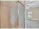 Tiled shower with glass door leading to a bedroom with neutral walls and carpeting at 2311 Whitley Ln, Winter Haven, FL 33881