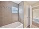 Tiled bathroom with tub and shower combination and large window at 2311 Whitley Ln, Winter Haven, FL 33881
