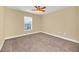 Spacious bedroom with neutral walls, carpet, ceiling fan, and a bright window at 2311 Whitley Ln, Winter Haven, FL 33881