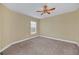This bedroom features neutral walls, carpeted flooring, a ceiling fan, and a window for natural light at 2311 Whitley Ln, Winter Haven, FL 33881