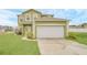Charming two-story home with a two-car garage, manicured lawn, and lush landscaping at 2311 Whitley Ln, Winter Haven, FL 33881