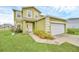 Charming two-story home with a two-car garage, manicured lawn, and lush landscaping at 2311 Whitley Ln, Winter Haven, FL 33881